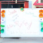 Outdoor notice board decorated with orange white and green paper flowers handwritten independence day messages and sasthi welcomes all text Sarathi school habsiguda hyderabad