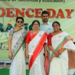 Group of four adults in traditional indian sarees posing for a photo at an independence day celebration each wearing indian flag pins Sarathi school habsiguda hyderabad