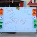 Outdoor bulletin board with handwritten independence day messages and orange blue and green flower decorations along the edges Sarathi school habsiguda hyderabad