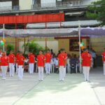 Group of schoolchildren in red polo shirts and white pants standing in a line on an outdoor courtyard during a ceremony sarathi school habsiguda hyderabad