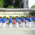 Group of schoolchildren in blue shirts and white pants standing in rows for a ceremony under a white canopy Sarathi school habsiguda hyderabad