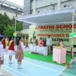 Students in uniform stand in a parade line during an independence day celebration at sarasthi school with a bannered stage and indian flags nearby sarathi school habsiguda hyderabad