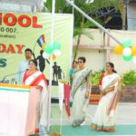 School independence day stage woman speaks at a podium while teachers stand nearby with a tricolor banner and balloons in the background  sarathi school habsiguda hyderabad