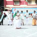 Group of students in period costumes standing in a schoolyard during a quit india movement 1942 event holding sashes and an indian flag beside a banner Sarathi school habsiguda hyderabad