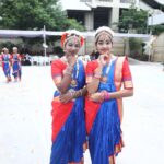 Two young indian classical dancers in matching blue and red costumes pose together outdoors wearing ornate headpieces and jewelry Sarathi school habsiguda hyderabad